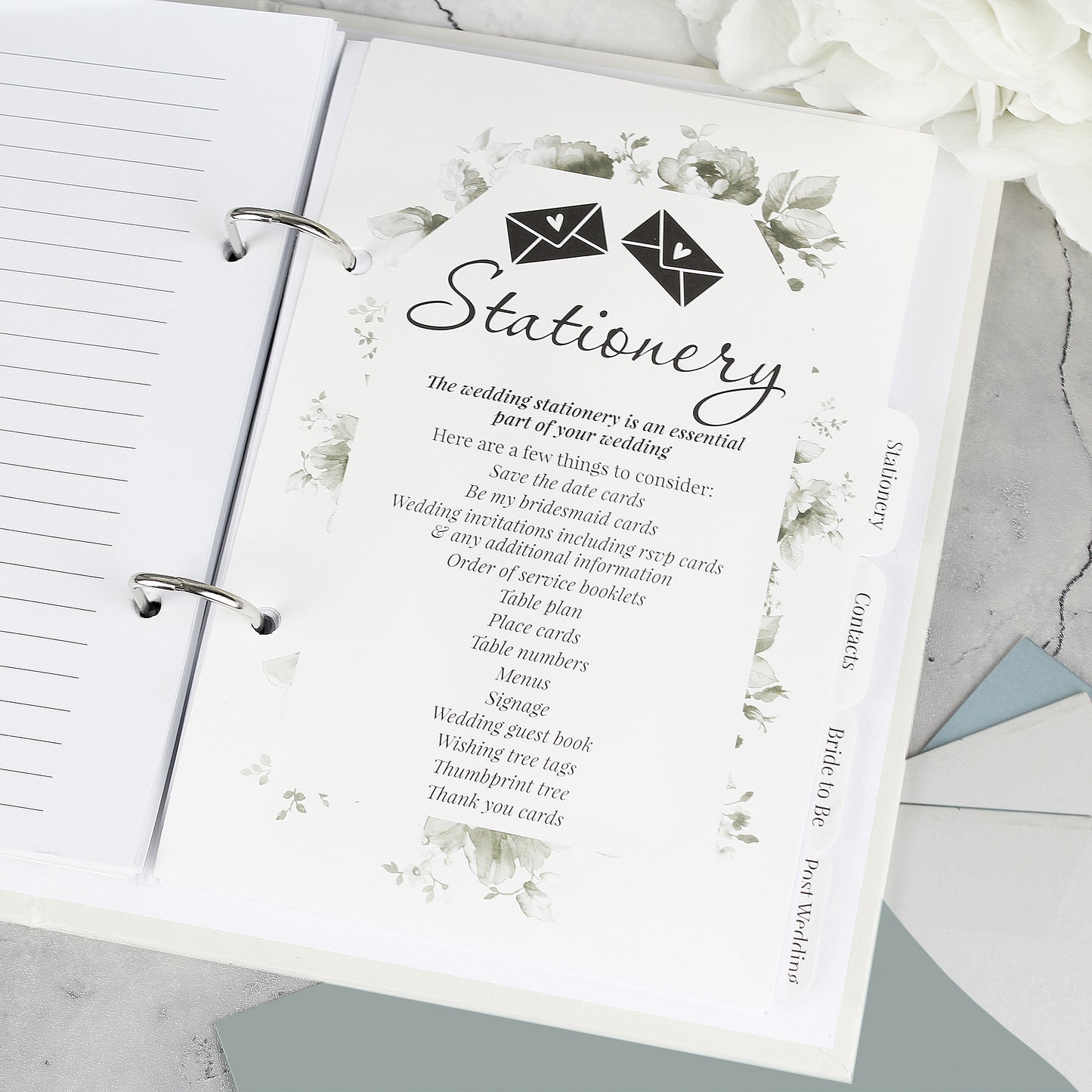 Stationery planner with floral design and text on a marble surface