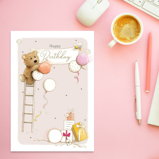 Cute Barley Bear character up a ladder hanging banner and balloons