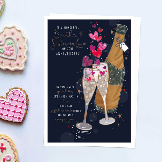 Front image of card with bottle of bubbly and glasses with hearts and verse. Dark background with foil rose gold details