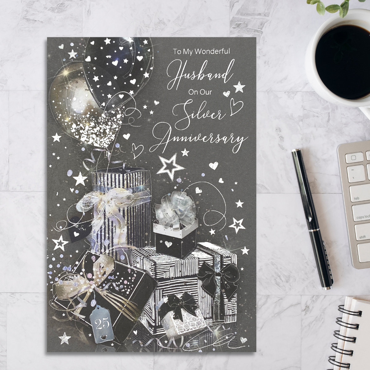 Grey card with black and silver gifts and balloons with foil details.