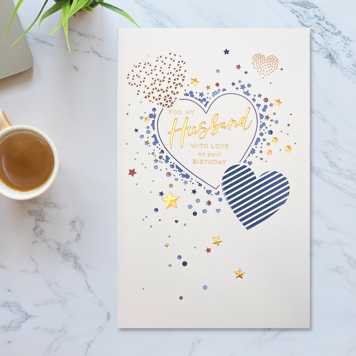 White card with heart shape cut outs to reveal blue card inside and gold foil details