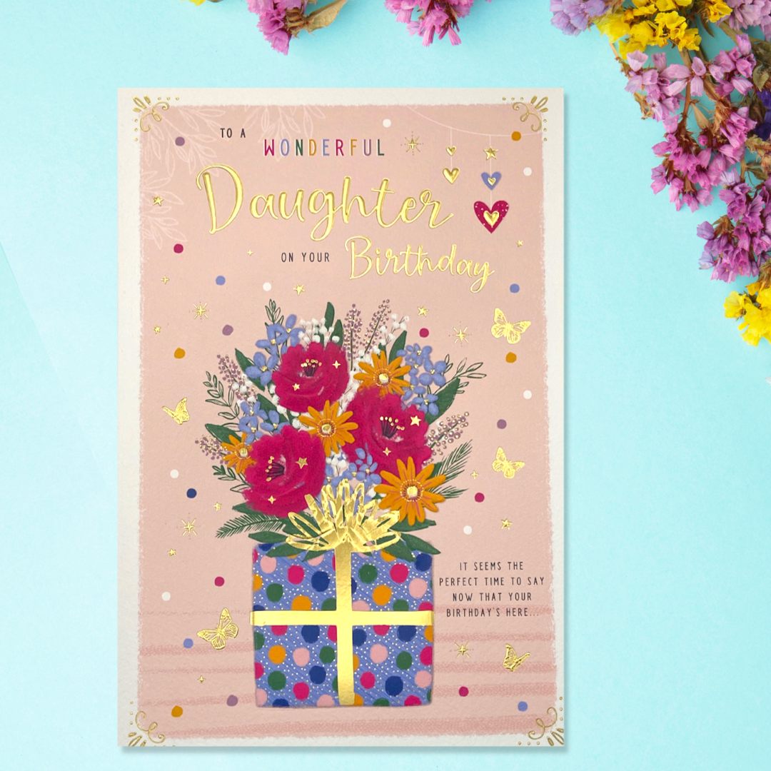 Front image of card featuring pink card with polka dot present of flowers
