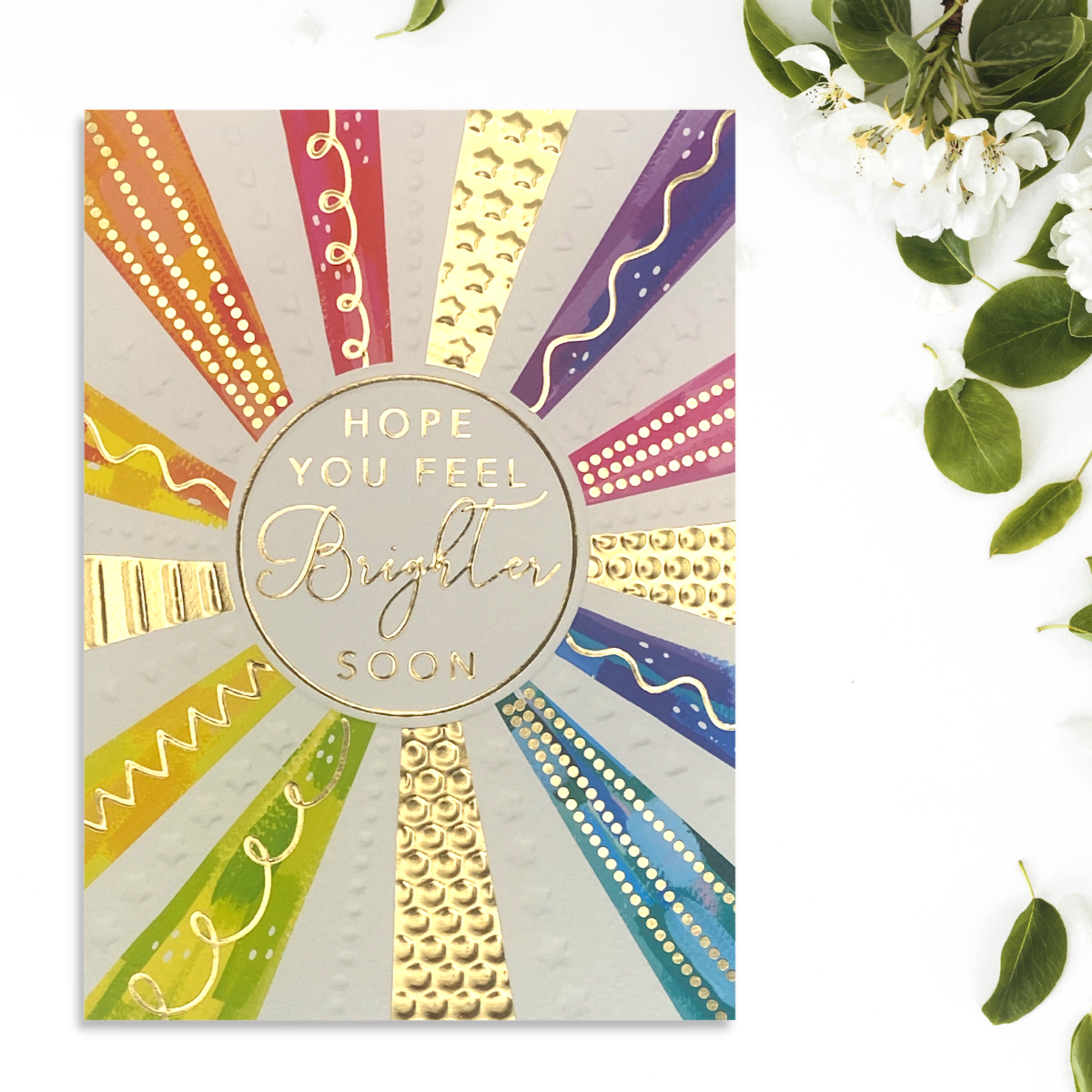 Front image showing multicolour rainbow stripes with gold details and gold text