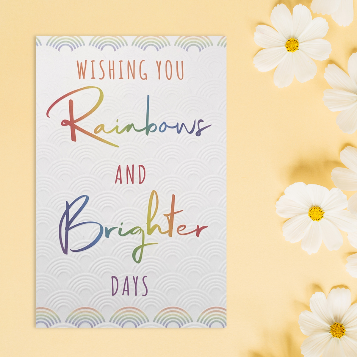 Front image with white embossed rainbows and multicolour rainbow text