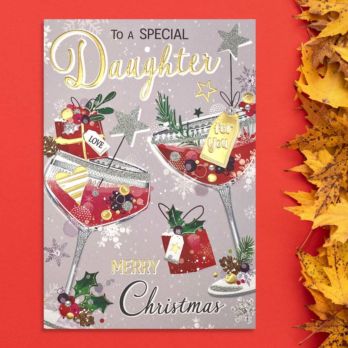 pink card with two cocktails and gifts with festive decorations
