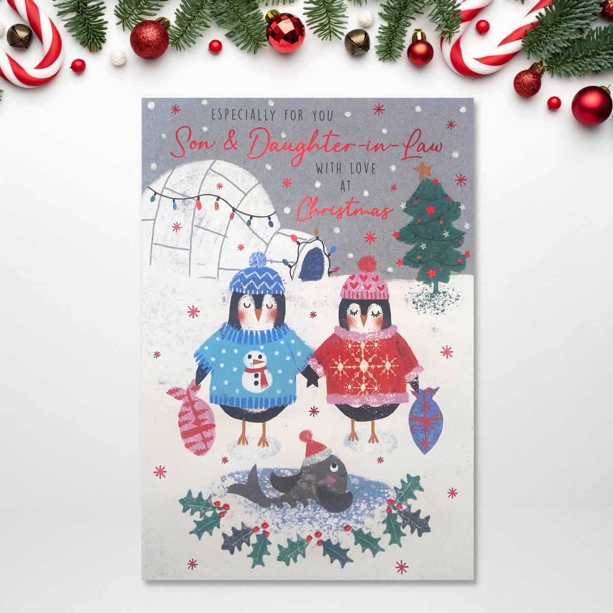 Two cartoon penguins in  the snow with igloo and whale