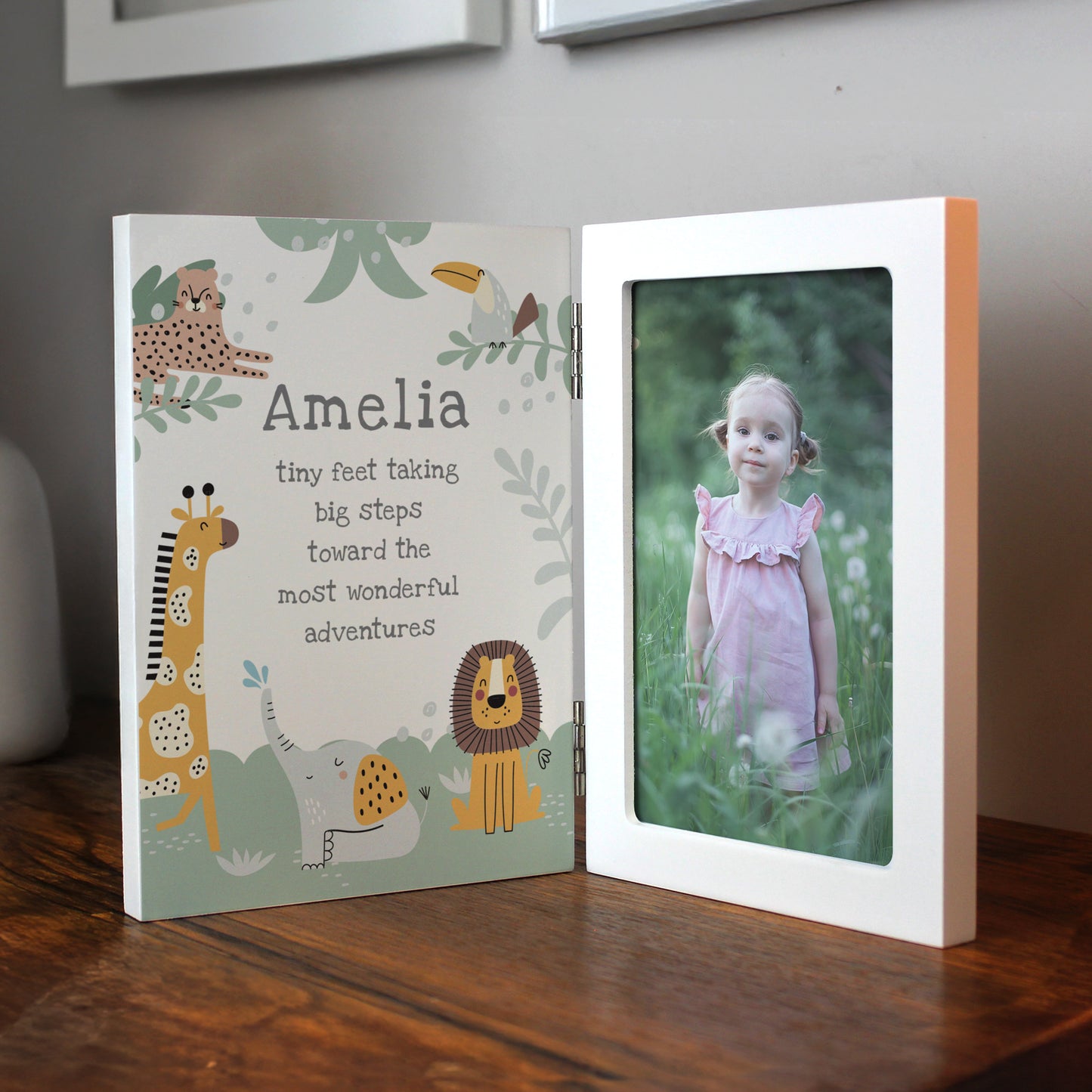 Open photo frame with a photo of a child on a wooden surface