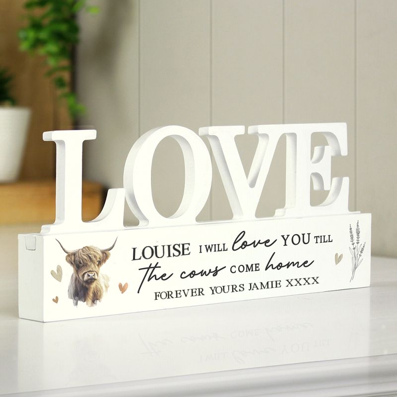 Decorative sign with 'LOVE' and personalised message on a white surface.