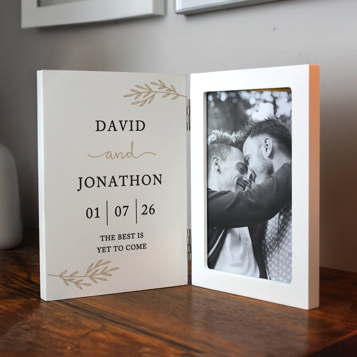 Personalised photo album with a black and white photo of two people and text on a wooden surface.