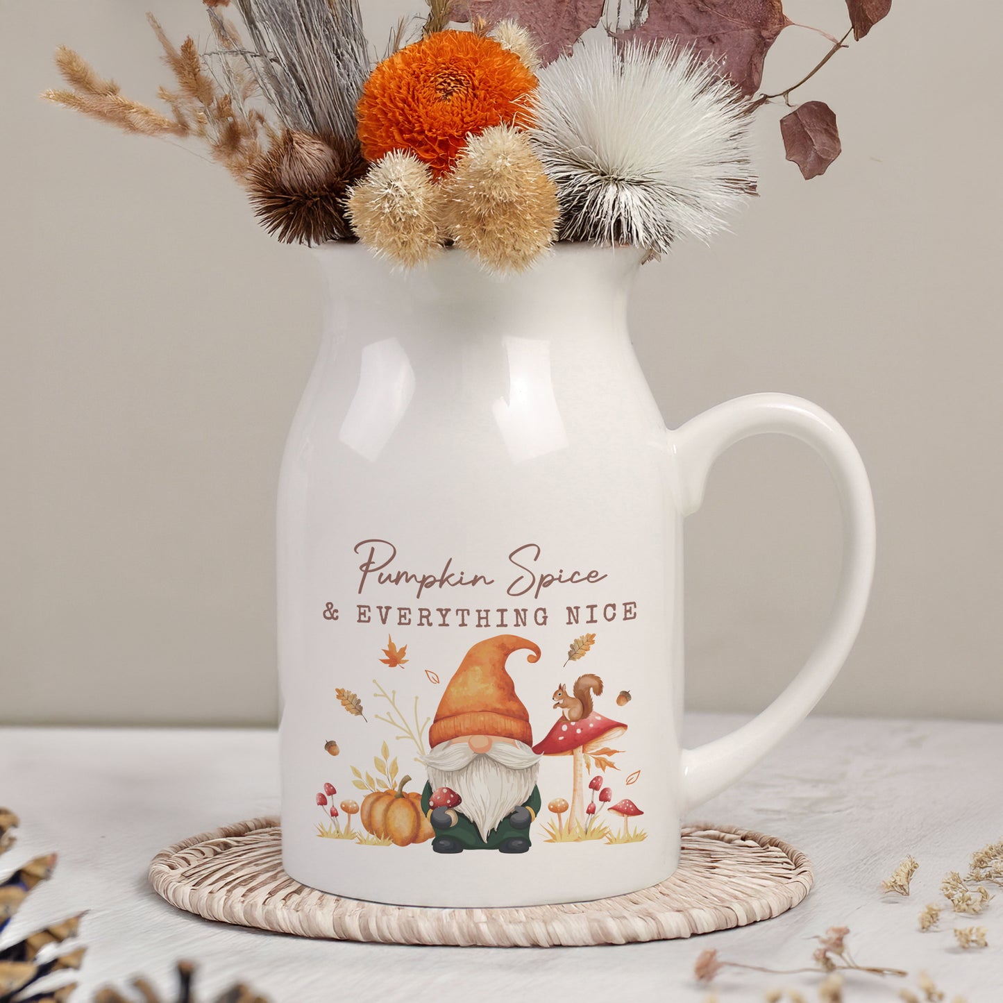 White mug with 'Pumpkin Spice & Everything Nice' text and gnome design, filled with autumn-themed decorations.