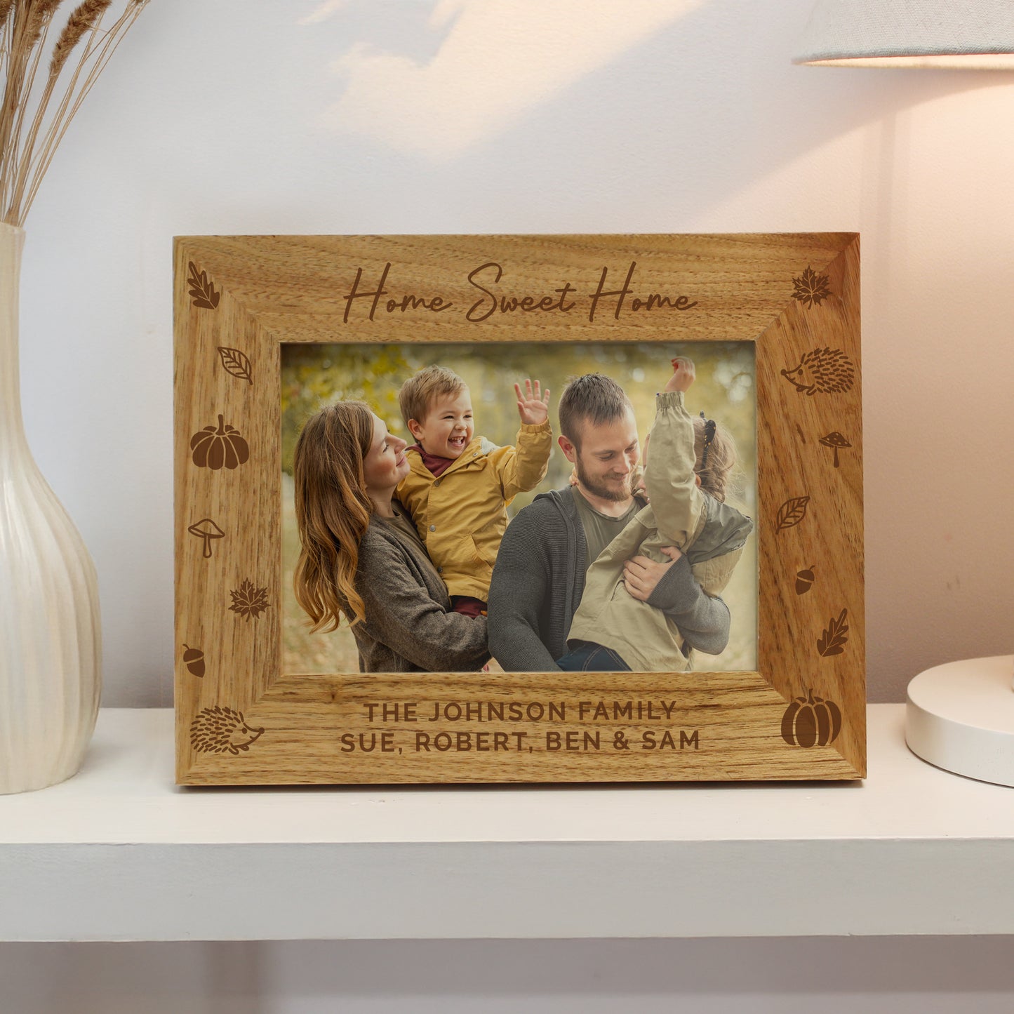 Personalised Autumn themed wooden photo frame with family photo and engraved text on a shelf.