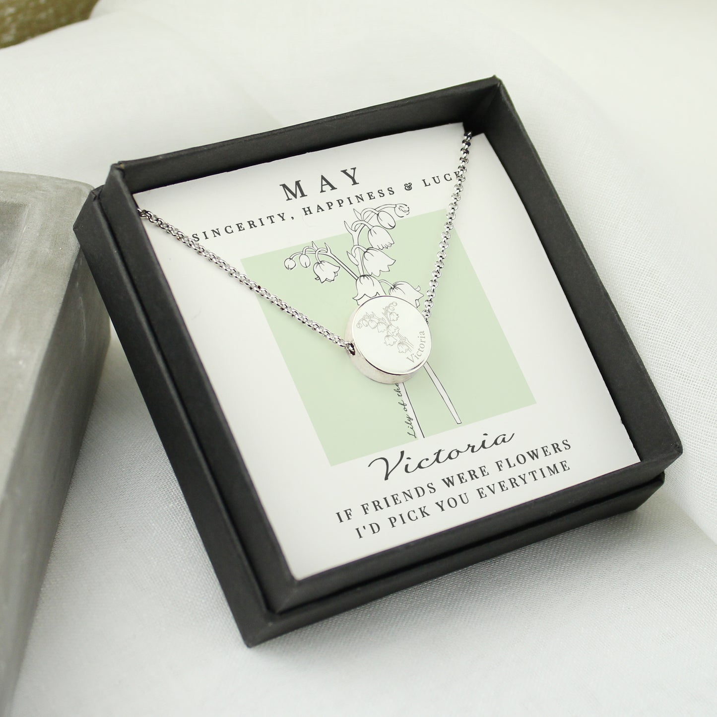 Silver coloured necklace with floral design in a decorative box on a light surface