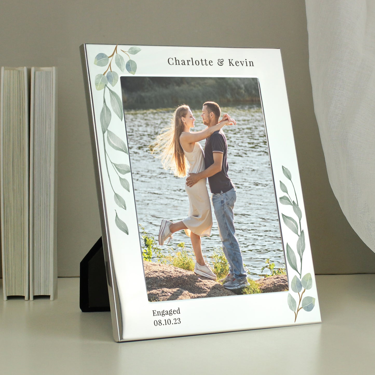 A silver 5x7 photo frame with a botanical design, personalised with a message, displaying a couple's wedding photo.