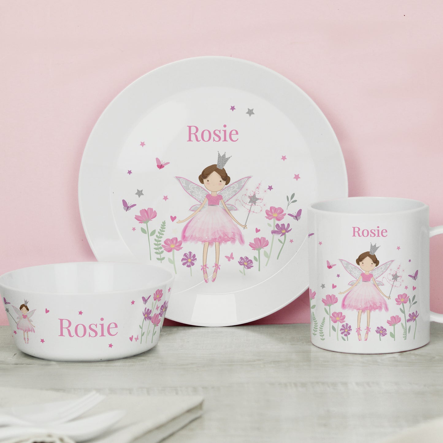Children's dinnerware set with fairy design and 'Rosie' text on a pink background