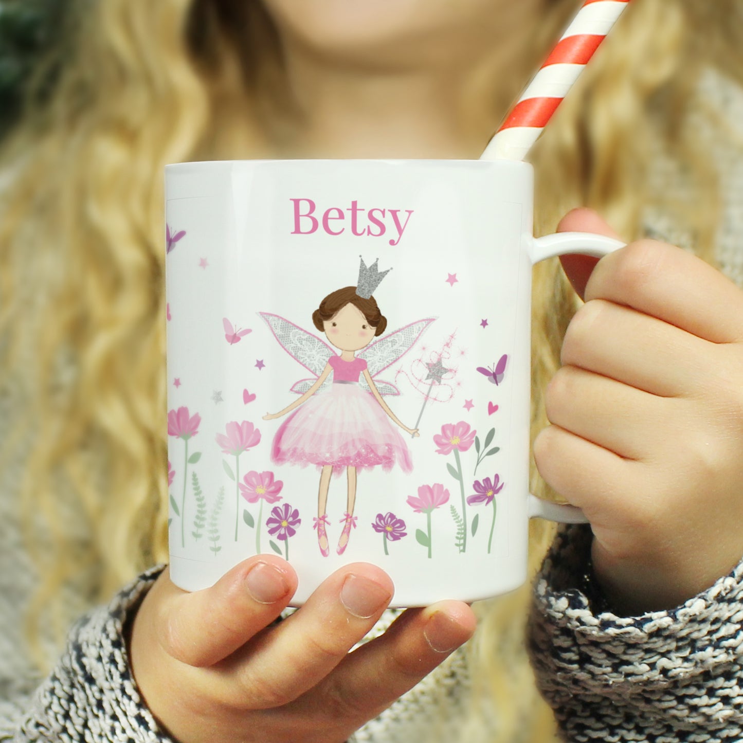 Person holding a mug with a fairy design and the name 'Betsy' on it.