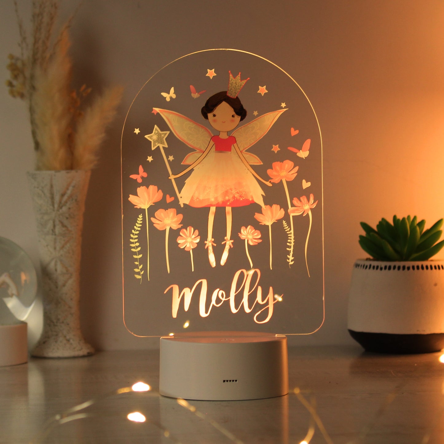 Fairy-themed night light with 'Molly' on a table with decorative plants.