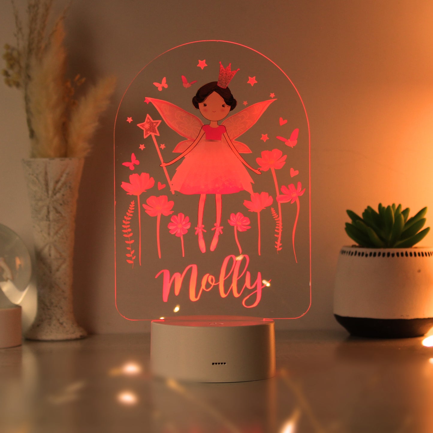 Fairy-themed night light with 'Molly' on a table with decorative plants.