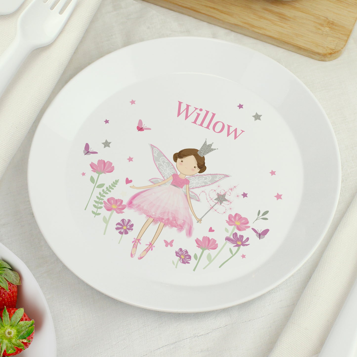 Children's plate with a fairy design and the name 'Willow' on a table setting.