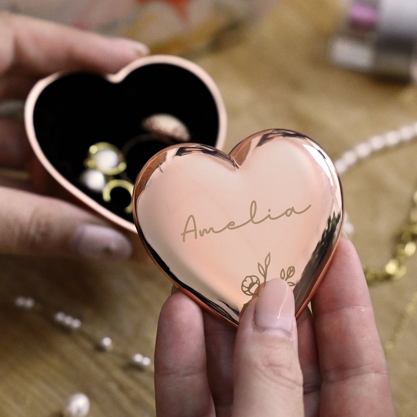 Heart-shaped rose gold trinket box with 'Amelia' engraved, held by a hand.