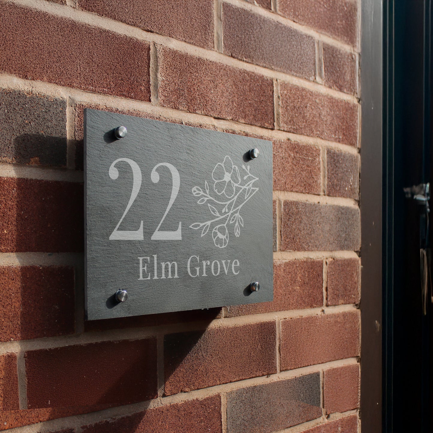 House number sign '22 Elm Grove' on a brick wall