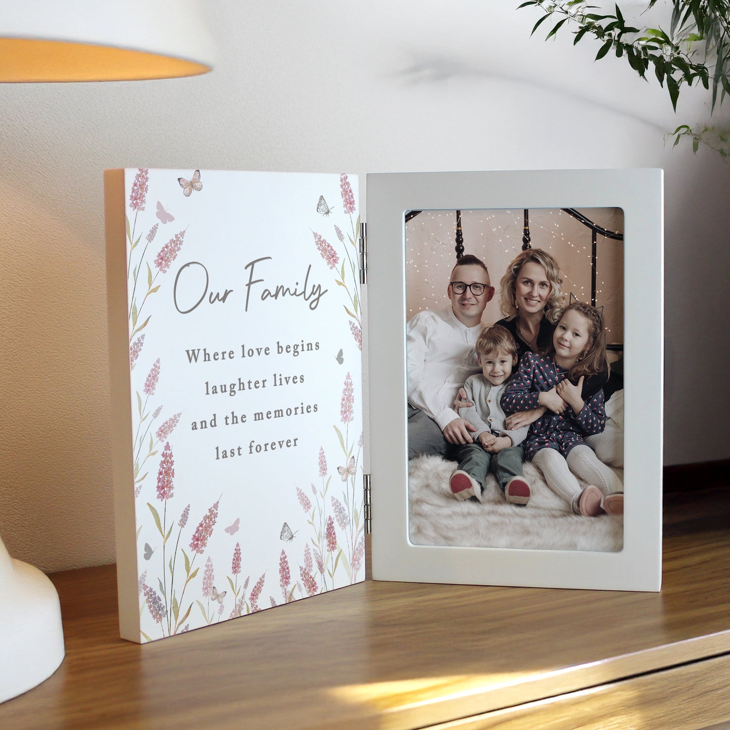 Personalised photo album with floral design and family photo on a wooden surface.