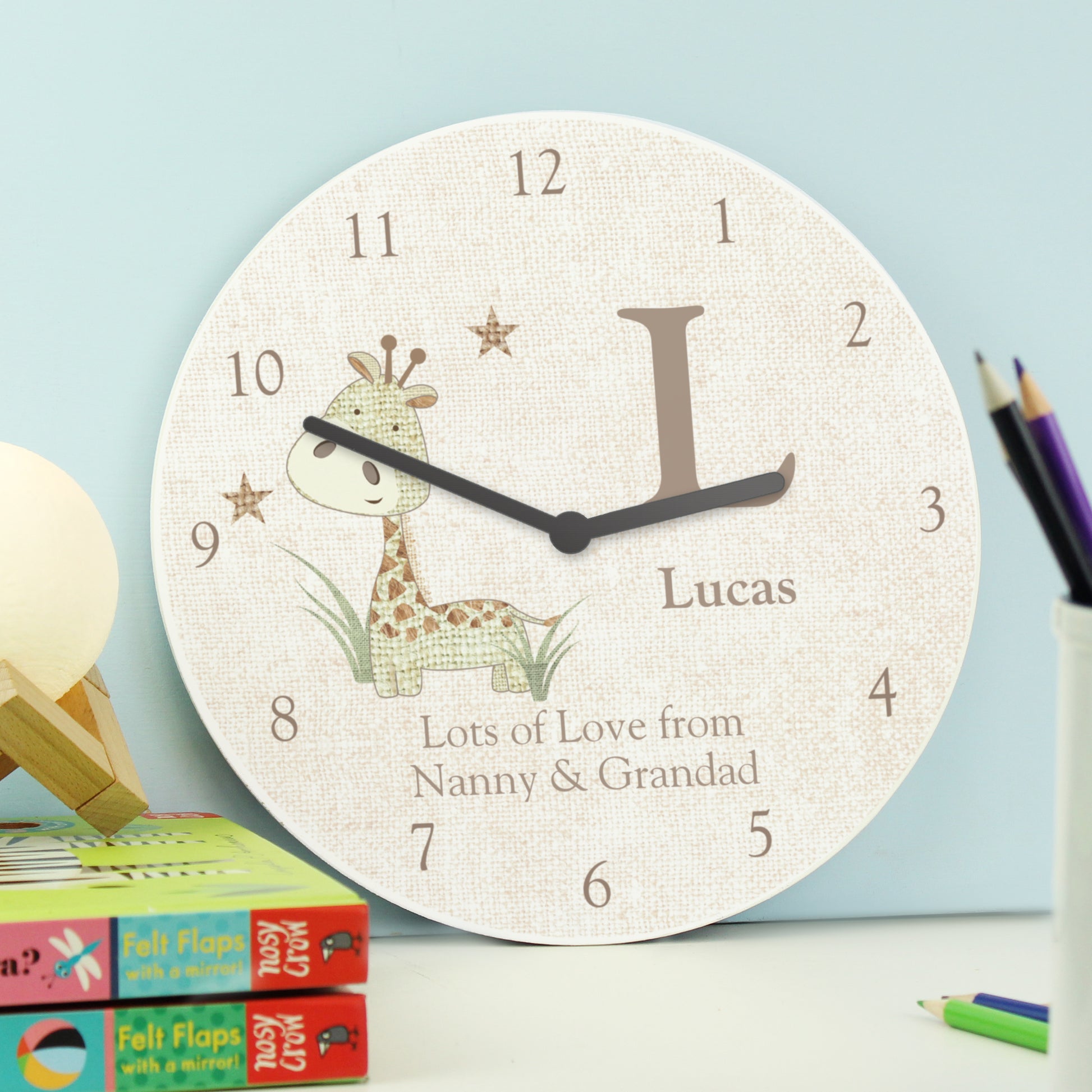 Wooden personalised clock shown on a shelf .