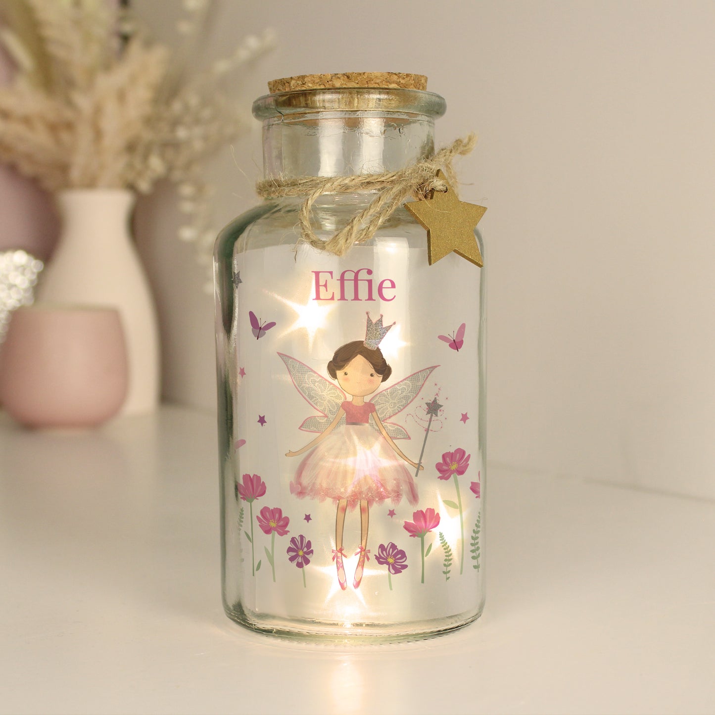 Decorative glass jar with fairy design and 'Effie' text, featuring fairy lights inside.