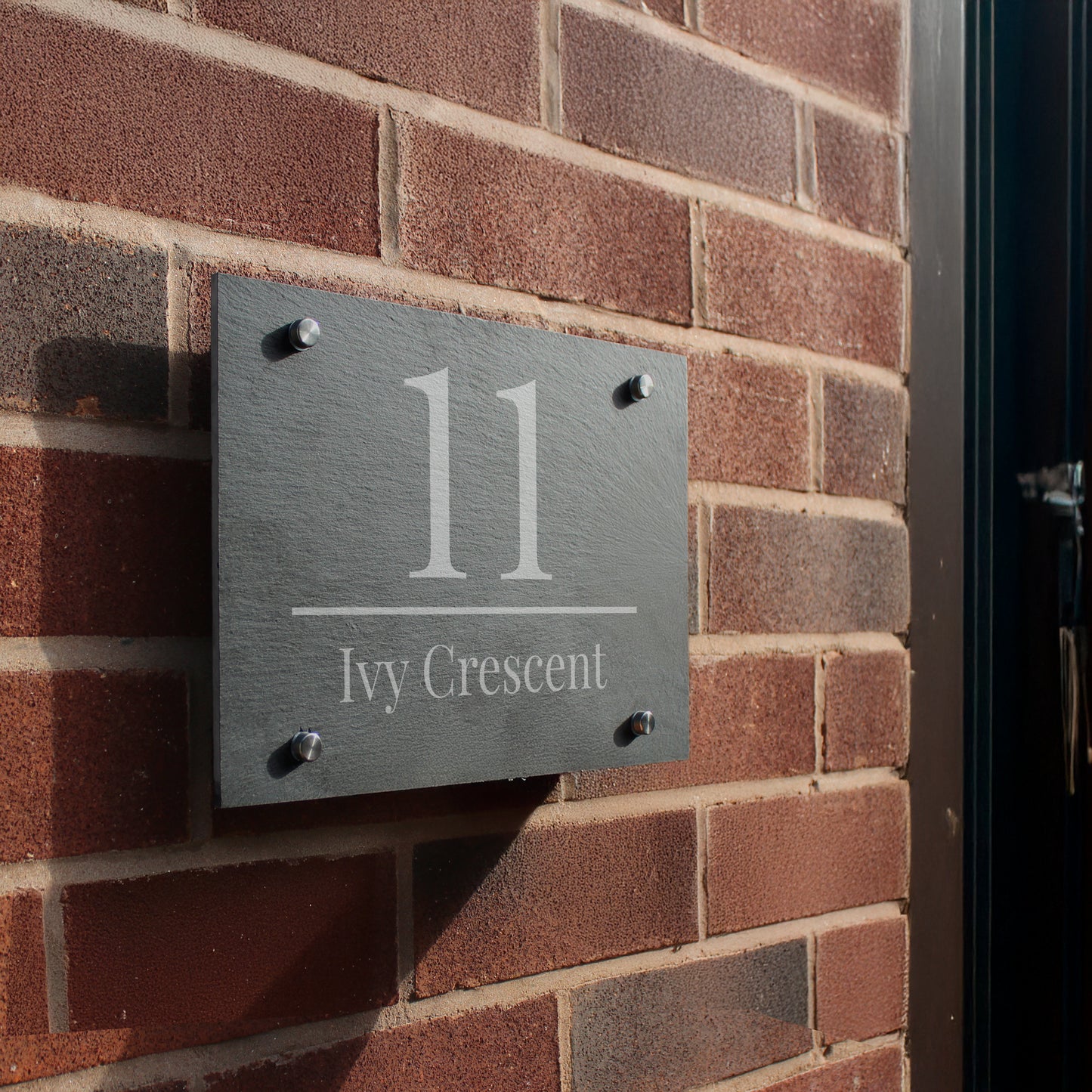 House number sign '11 Ivy Crescent' on a brick wall