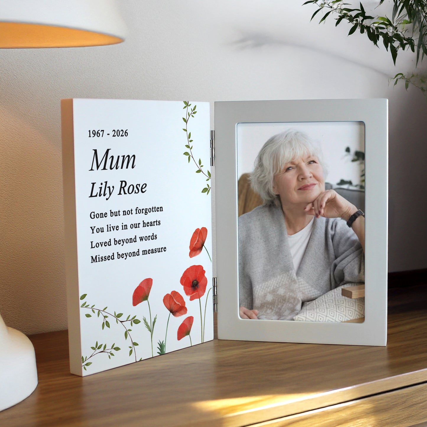 Memorial photo frame with a picture of an elderly woman and text on a table.