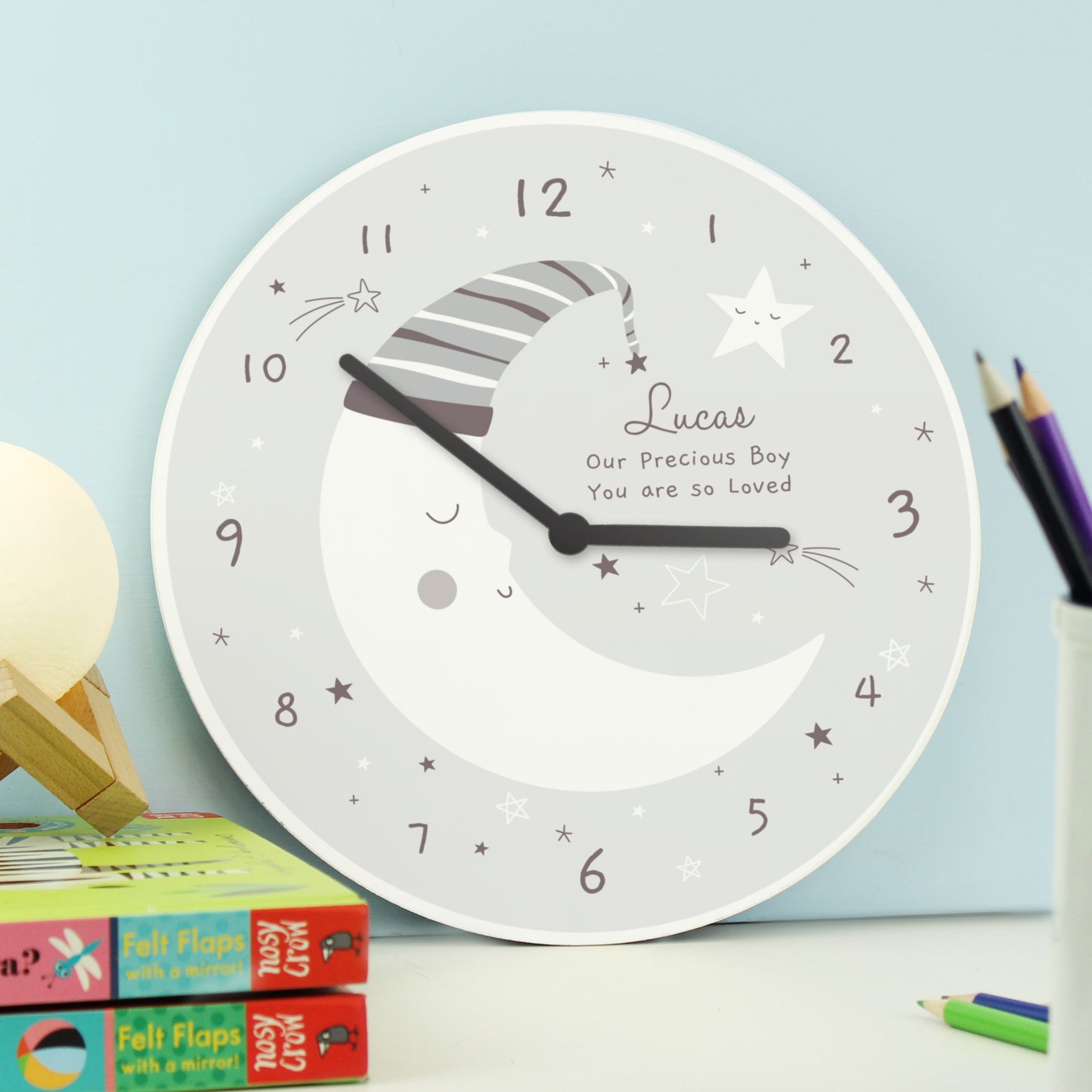 Children's wall clock with personalized message on a light blue background