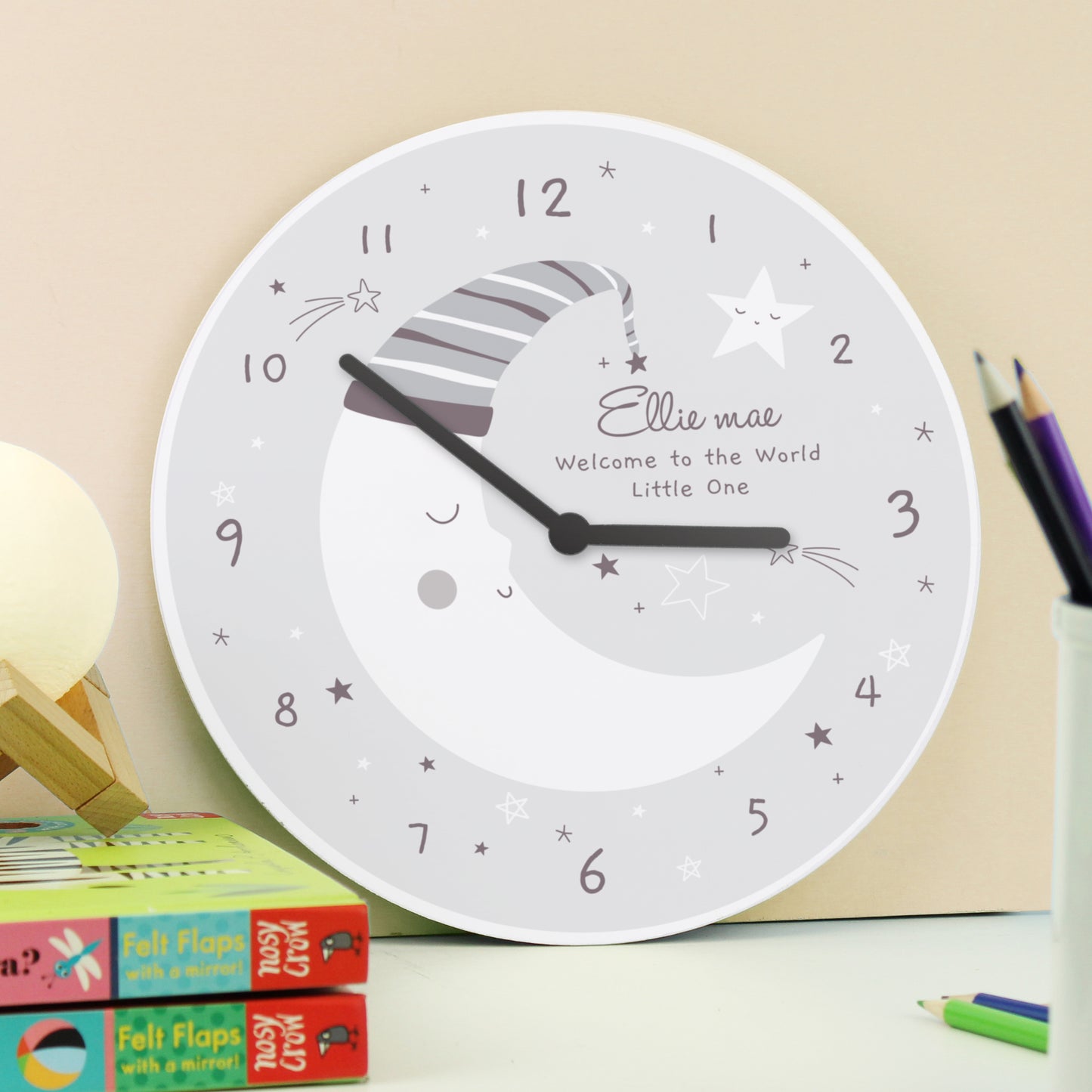 White clock with personalized text on a surface with stationery items