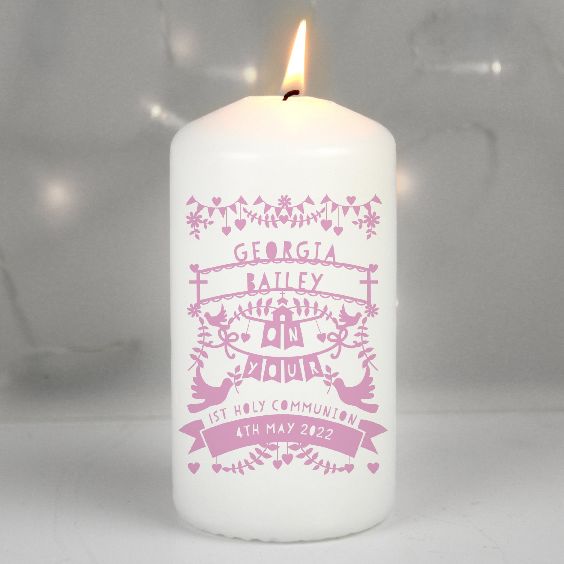 White candle with pink personalised text on a white background