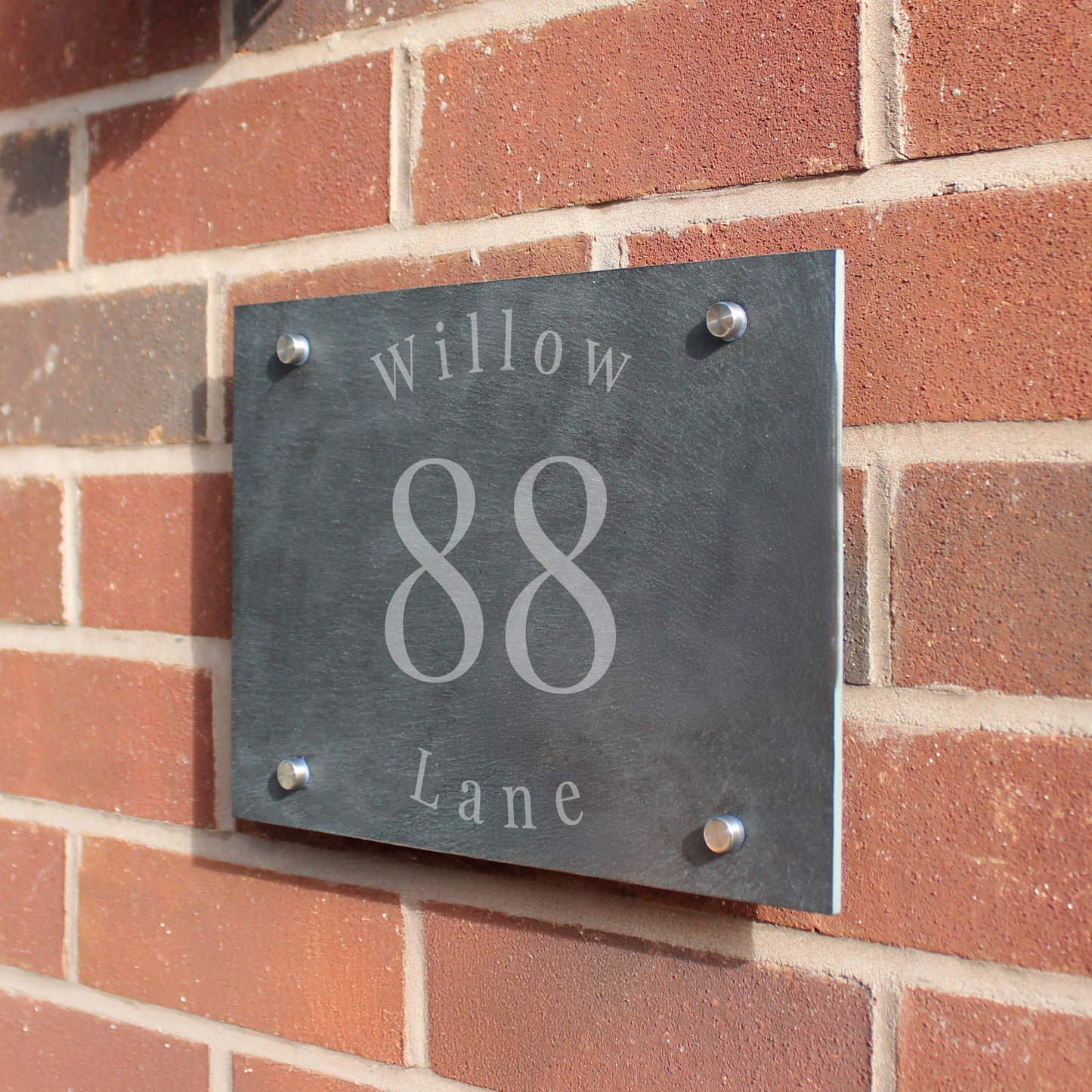 House number sign '88 Willow Lane' on a brick wall