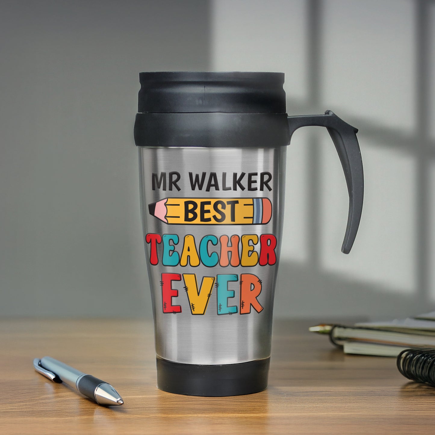 Travel mug with 'MR WALKER BEST TEACHER EVER' text on a wooden surface.