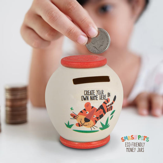 Small single use Smash Pot with Create Your Own Name sticker and colourful image of a tiger. When filled with money smash, empty and bury pieces in the compost. Ivory with orange top and base.
