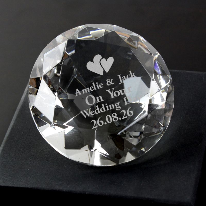 Crystal paperweight with engraved text and hearts on a black background