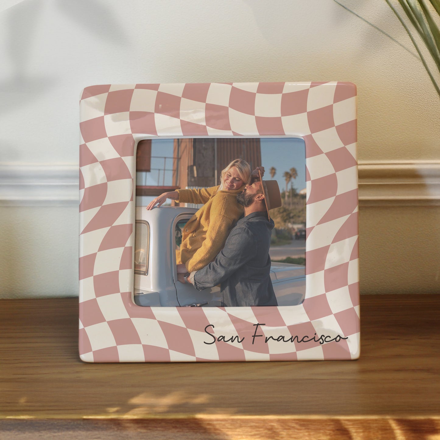 Checkered photo frame with a couple in San Francisco on a wooden surface