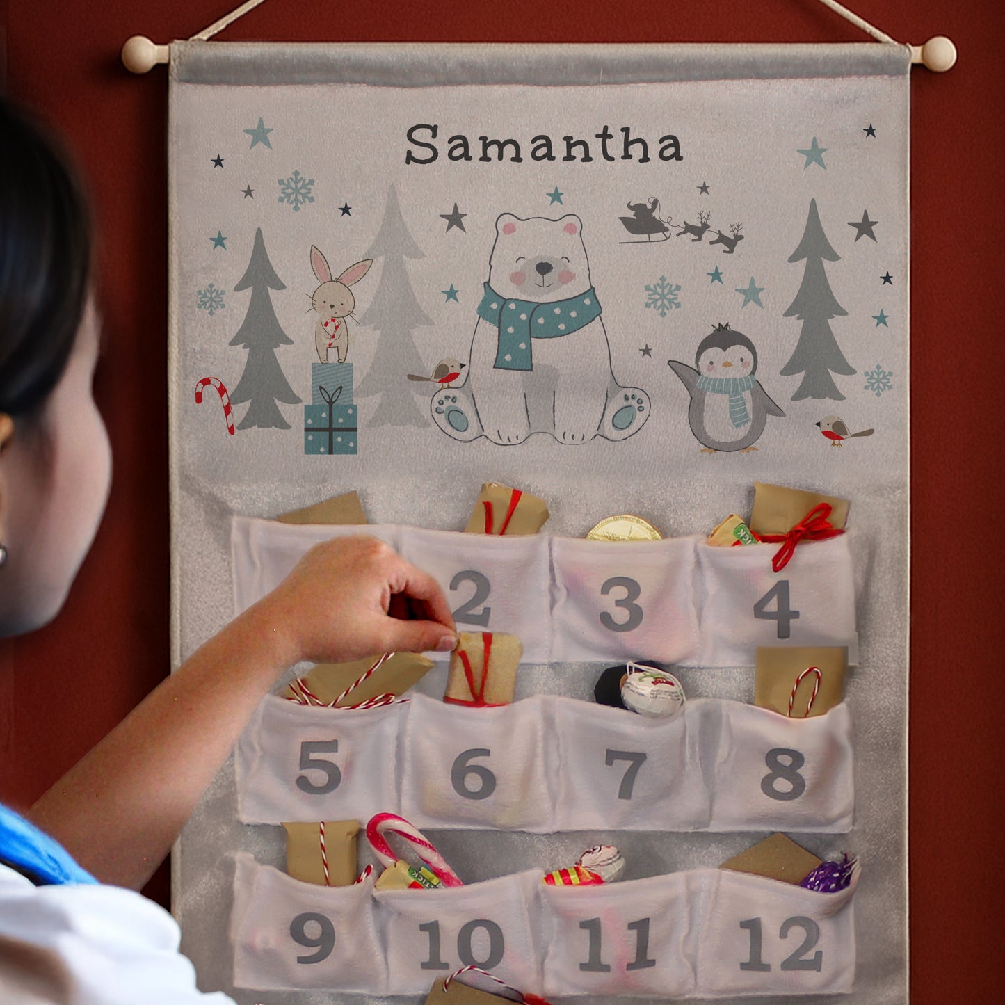 Advent calendar with festive designs and numbers, being interacted with by a child.