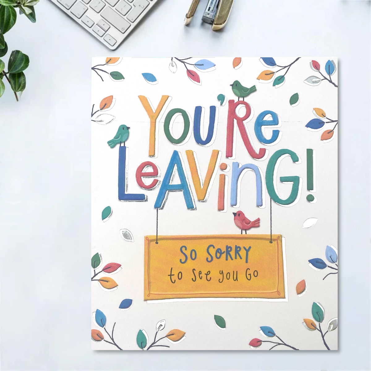 White card with multicolour birds and leaves, besides bold text
