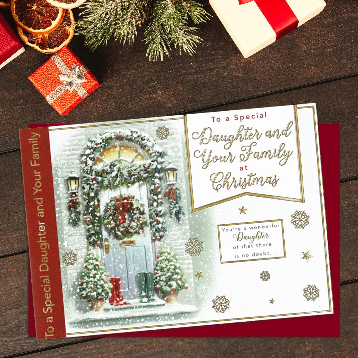 To A Special Daughter And Your Family At Christmas. Showing A Festive Scene Of Decorated Front Door. Lettering And Snowflakes In Gold Foil. Finished With A Red Envelope