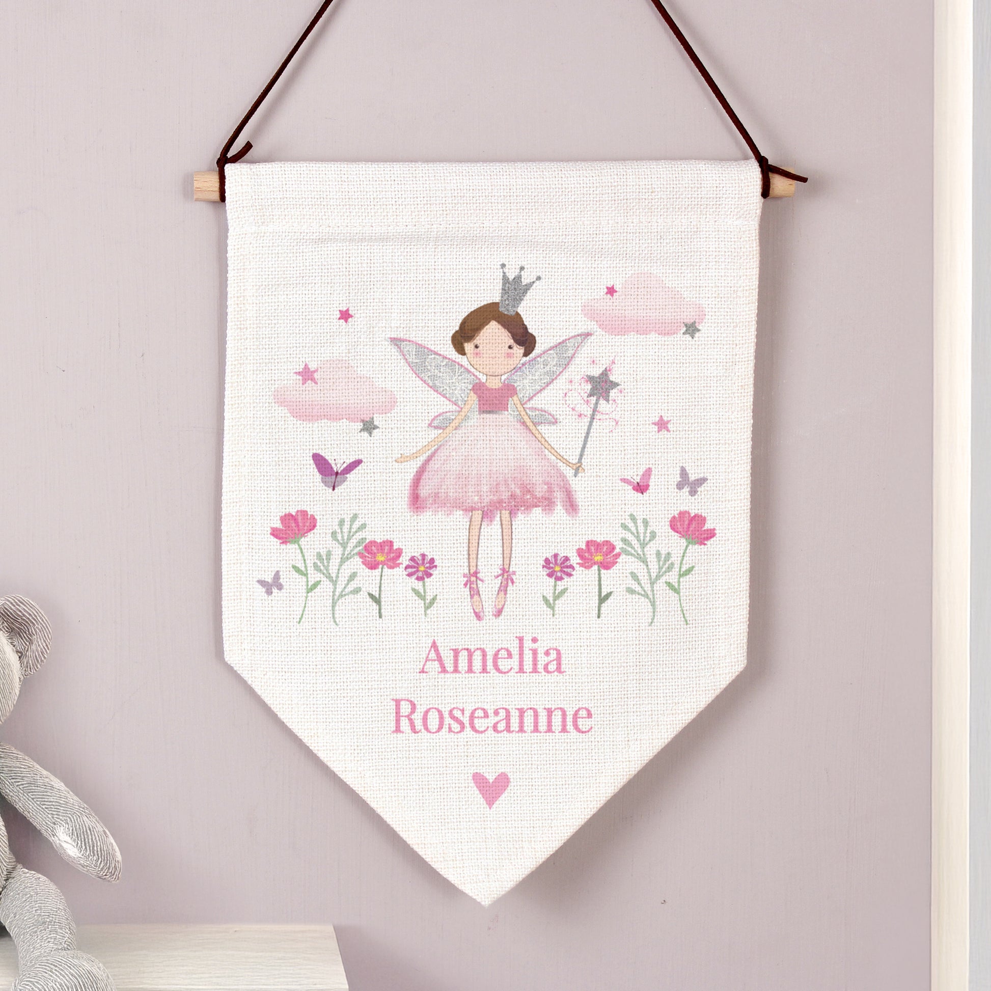 Fairy-themed decorative banner with flowers and a name on a light purple wall.