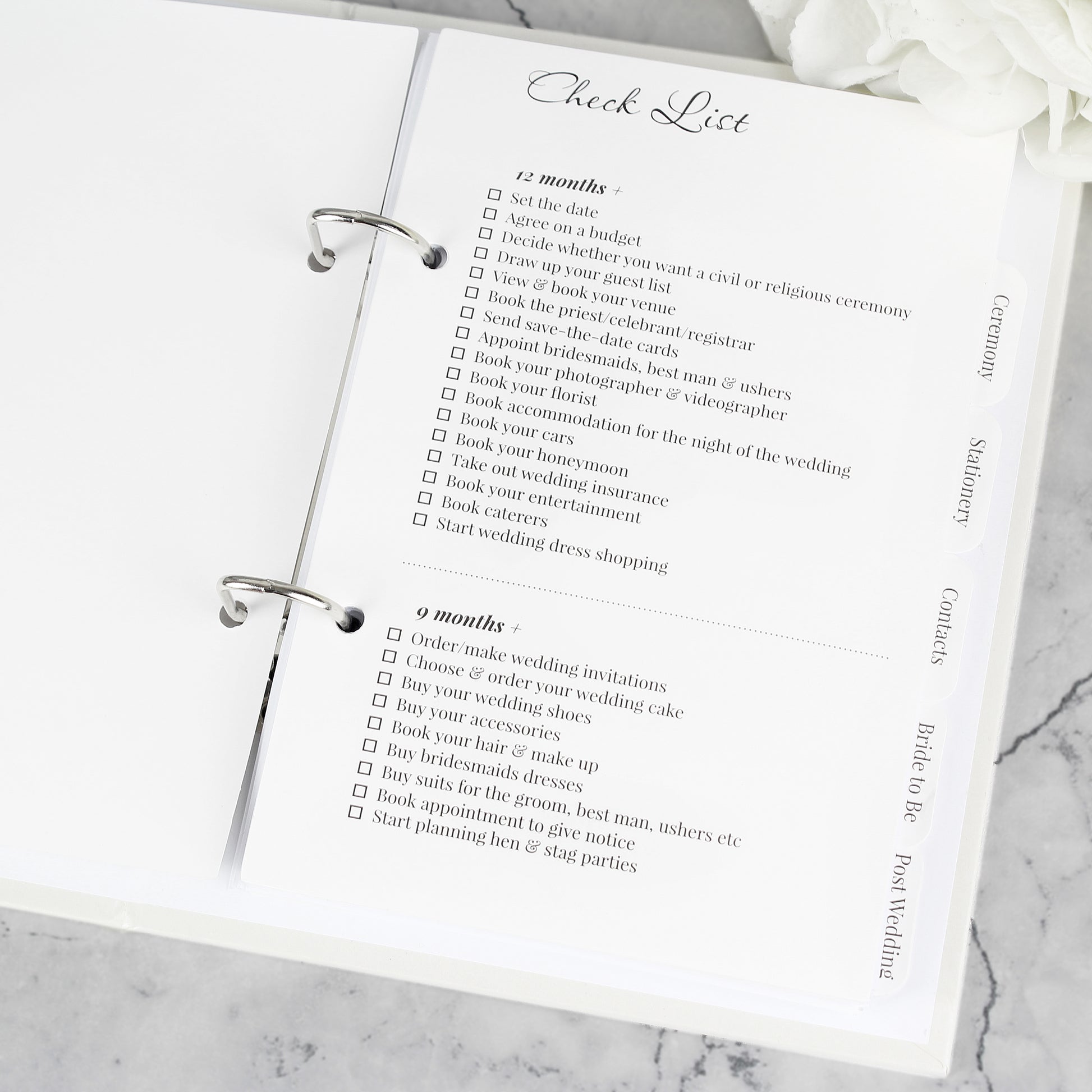 Wedding planning checklist on a marble surface