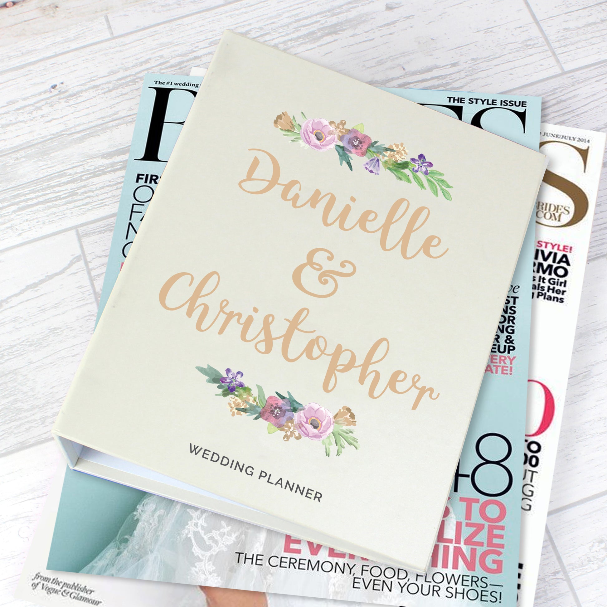 Wedding planner with personalized names on a magazine stack