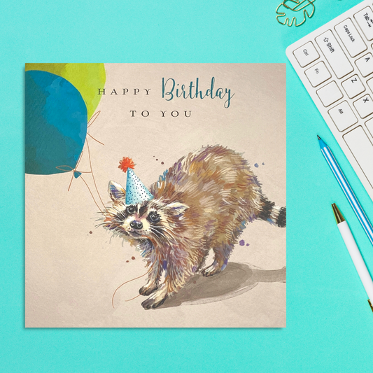 Square card featuring a raccoon in party hat and balloons