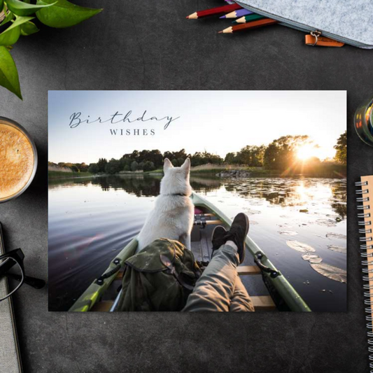 Landscape card with a man, and his dog on boat ona lake.