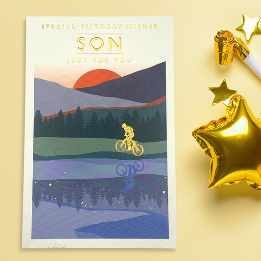 Cyclist in gold foil riding through sunset
