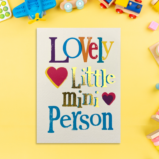 Brightly coloured new baby card with coloured text, red heart and gold foil