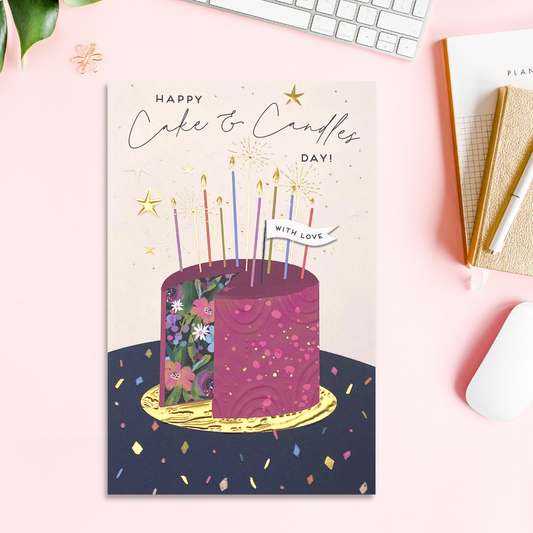 Front image with purple floral cake, candles, confetti and gold foil details