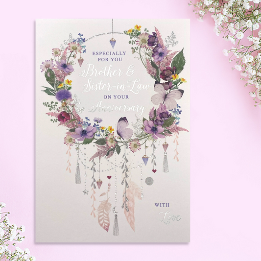 Front image of anniversary card with floral wreath featuring butterflies and feathers