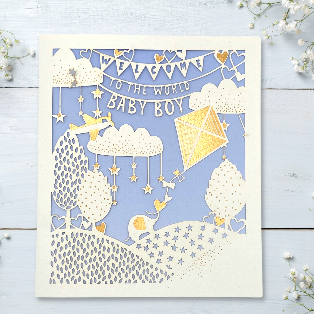 Front image of lace design die cut card with blue background and white and gold decorations